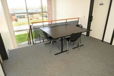 a table and chairs in a room with a large window at Sport & Academy in Farsø