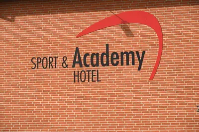 a brick wall with a sign for a spa and academy hot at Sport & Academy in Farsø