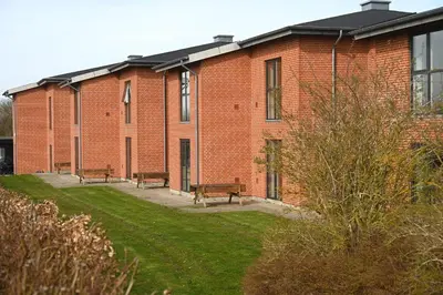 a brick building with benches in front of it at Sport & Academy in Farsø