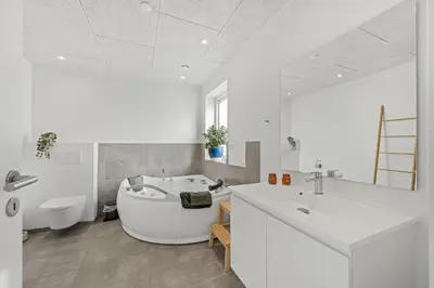 a white bathroom with a tub and a sink at Pool House With Activity Room, Built In 2020, With A View Of The North Sea in Nørre Vorupør