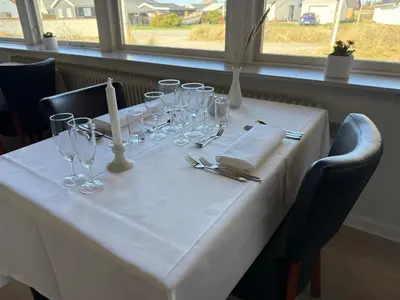 a white table with glasses and napkins on it at VØ Drop Inn in Nørre Vorupør