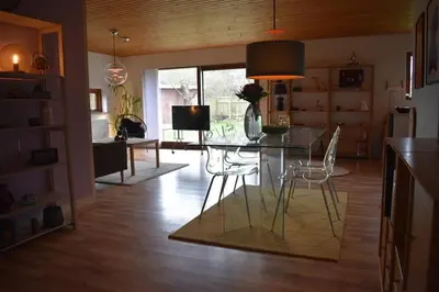 a dining room with a glass table and chairs at Viking Surf Camp in Klitmøller