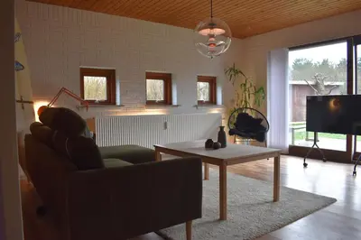 a living room with a couch and a table and a tv at Viking Surf Camp in Klitmøller