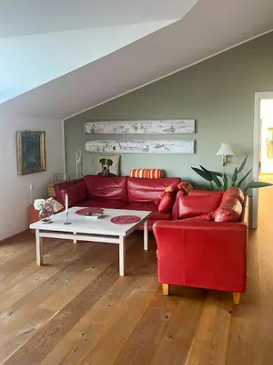a living room with a red couch and a table at Architect-Designed House With Private Beach in Løgstrup