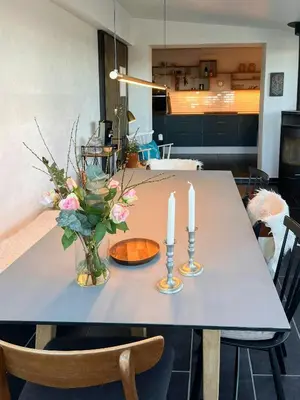 a table with two candles and a vase with flowers on it at Charming Town House In Thyborøn Near The North Sea in Thyborøn