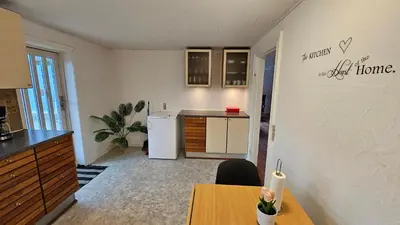 a kitchen with a table and a refrigerator and a counter at Nattely i Thy in Thisted