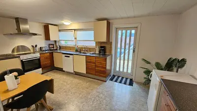 a large kitchen with a table and a dining room at Nattely i Thy in Thisted