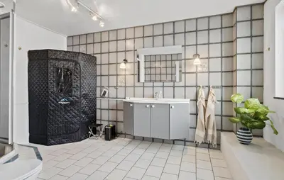 a bathroom with a black and white tiled wall at 5 Bedroom Nice Home In Blokhus in Blokhus