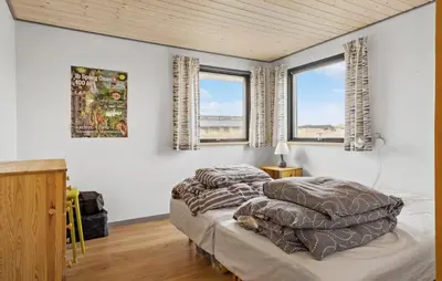 two beds in a bedroom with two windows at 5 Bedroom Lovely Home In Saltum in Saltum