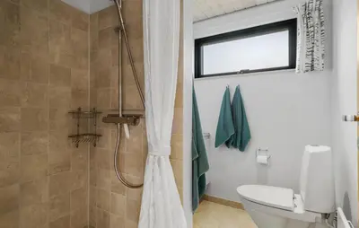 a bathroom with a shower with a toilet and a window at 5 Bedroom Lovely Home In Saltum in Saltum
