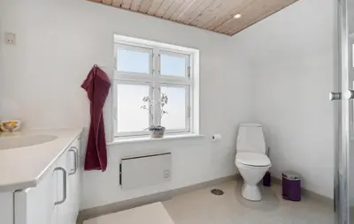 a white bathroom with a toilet and a window at Nice Home In Thisted With Wifi in Thisted