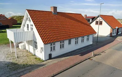 a white house with an orange roof on a street at Nice Home In Thisted With Wifi in Thisted