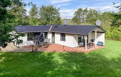 a white house with a black roof on a yard at Stunning Home In Øster Assels With Wifi in Øster Assels