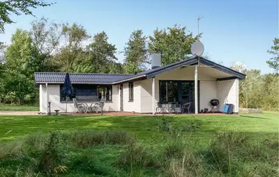 a small white house with a grass yard at Stunning Home In Øster Assels With Wifi in Øster Assels