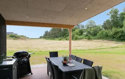 a patio with a table and chairs and a grill at Lovely Home In Spøttrup With Sauna in Spottrup