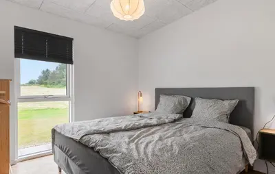 a bedroom with a bed with a large window at Lovely Home In Spøttrup With Sauna in Spottrup