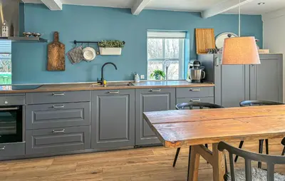 a kitchen with blue walls and a wooden table at 2 Bedroom Beautiful Home In Vinderup in Vinderup