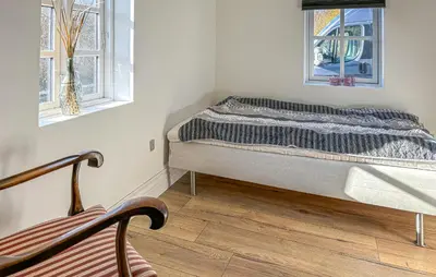 a bed sitting in a room with two windows at 2 Bedroom Beautiful Home In Vinderup in Vinderup