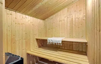 a wooden sauna with a towel sitting in it at Lovely Home In Fjerritslev With Sauna in Fjerritslev
