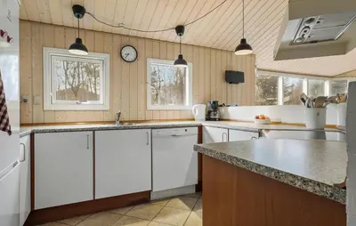 a kitchen with white cabinets and a clock on the wall at Lovely Home In Fjerritslev With Sauna in Fjerritslev