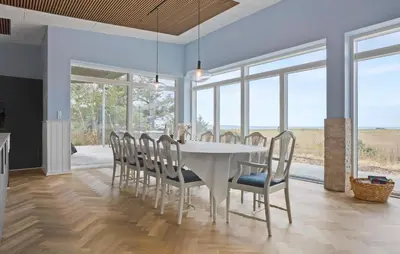 a dining room with a white table and chairs at Beach Front Home In Thyholm With Sauna in Thyholm