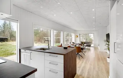 a kitchen with white cabinets and a dining room at 3 Bedroom Awesome Home In Fjerritslev in Fjerritslev