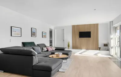 a living room with a black couch and a table at Amazing Home In Thyborøn With Sauna in Thyborøn