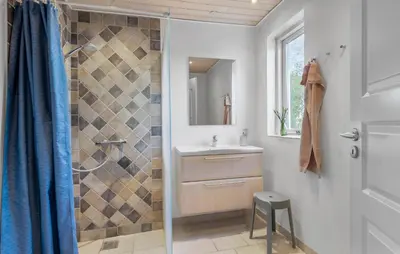 a bathroom with a shower and a sink and a mirror at Nice Home In Farsø With Wifi in Farsø