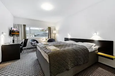 a hotel room with a large bed and a desk at Hotel Thisted in Thisted