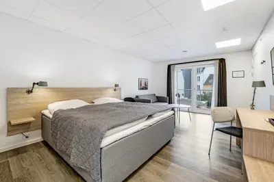 a bedroom with a large bed and a desk at Hotel Thisted in Thisted