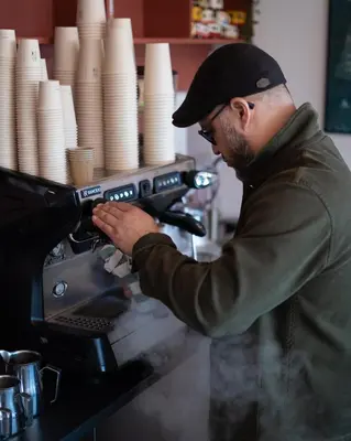 a man sitting at a coffee machine in a coffee shop at Holstebro Søpark in Holstebro