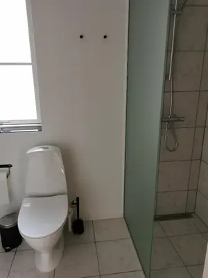 a bathroom with a toilet and a shower at Ferielejlighed in Nibe