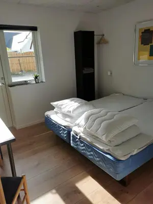 a bed in a room with a window at Ferielejlighed in Nibe