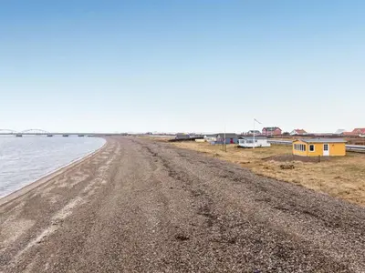 a dirt road next to a beach with houses at Holiday Home Nyalle - 50m to the fjord by Interhome in Struer