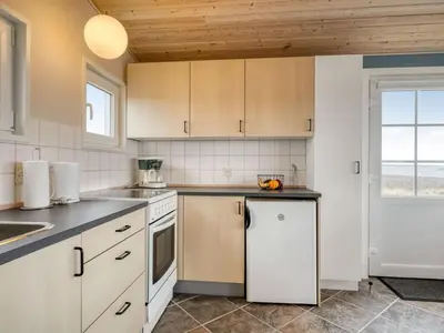 a kitchen with white cabinets and a white refrigerator at Holiday Home Nyalle - 50m to the fjord by Interhome in Struer