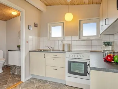 a kitchen with a stove and a sink at Holiday Home Nyalle - 50m to the fjord by Interhome in Struer