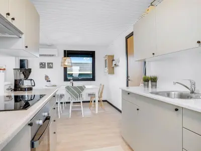 a kitchen with white cabinets and a counter top at Holiday Home Waghn - 250m from the sea by Interhome in Harboør