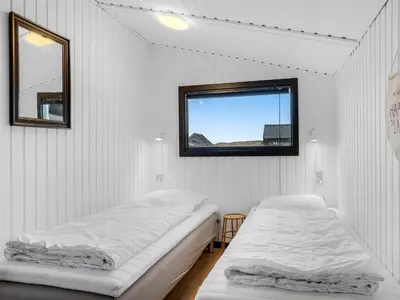 two beds in a white room with a window at Holiday Home Waghn - 250m from the sea by Interhome in Harboør
