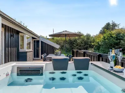 a hot tub on the deck of a house at Holiday Home Ilya - 1-7km from the sea by Interhome in Saltum
