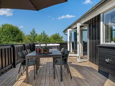 a patio with a table and chairs on a deck at Holiday Home Ilya - 1-7km from the sea by Interhome in Saltum