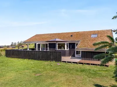 a house with a deck and a roof at Holiday Home Ilya - 1-7km from the sea by Interhome in Saltum