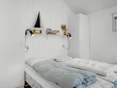 a white room with a large bed in it at Holiday Home Elisabete - 200m to the fjord by Interhome in Fur