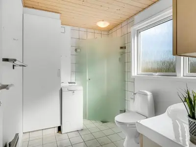 a bathroom with a toilet and a shower and a window at Holiday Home Elisabete - 200m to the fjord by Interhome in Fur