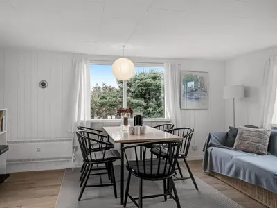 a living room with a table and chairs and a couch at Holiday Home Godja - 1km from the sea by Interhome in Blokhus
