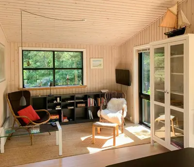 a living room with two chairs and a tv at Forest Cabin With Panoramic View Near Blokhus in Blokhus