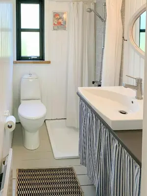 a bathroom with a toilet and a sink at Forest Cabin With Panoramic View Near Blokhus in Blokhus