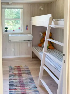a small room with two bunk beds and a window at Forest Cabin With Panoramic View Near Blokhus in Blokhus