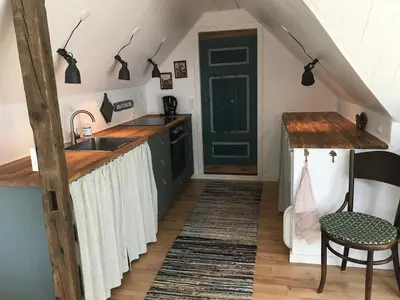 a kitchen with a sink and a green door at Kornloftet i Lodbjerg in Vestervig