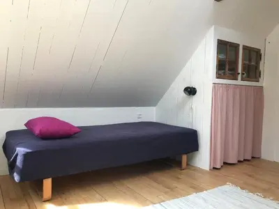 a bed with a purple pillow in a room at Kornloftet i Lodbjerg in Vestervig