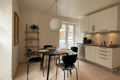 a kitchen with a table and chairs in a room at Cozy Scandinavian Apartment in the Heart of Viborg in Viborg